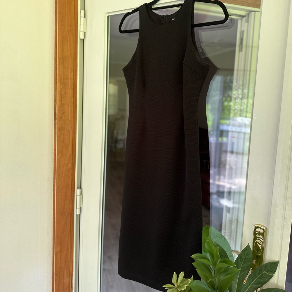 Black, form fitting, professional midi dress.